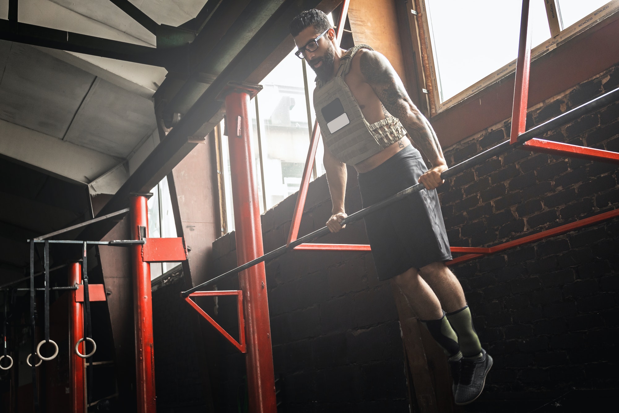 Strong man doing muscle up exercise in cross training gym